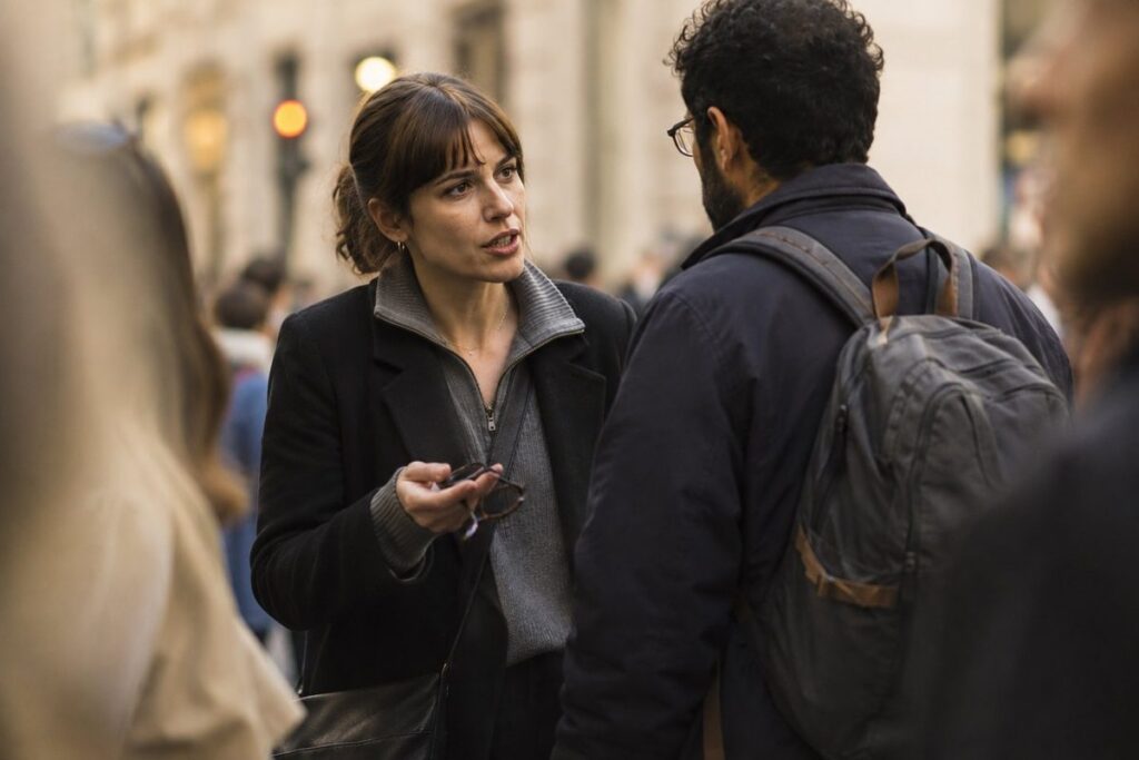 Woman speaking directly to a man on a busy city street, an example of assertive communication — Orpen Therapy Seattle